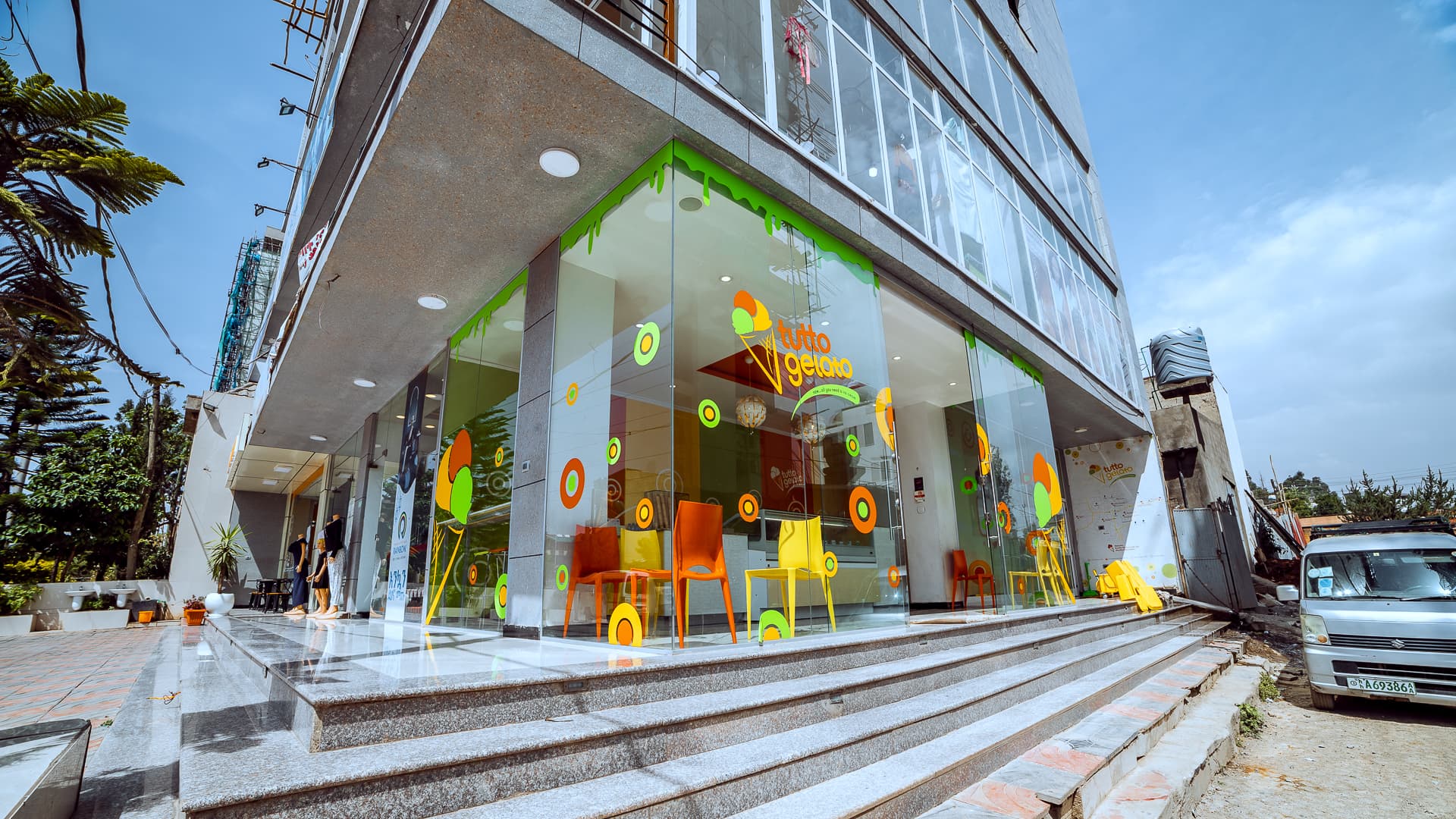 Corner view of the modern glass-fronted Tutto Gelato storefront building