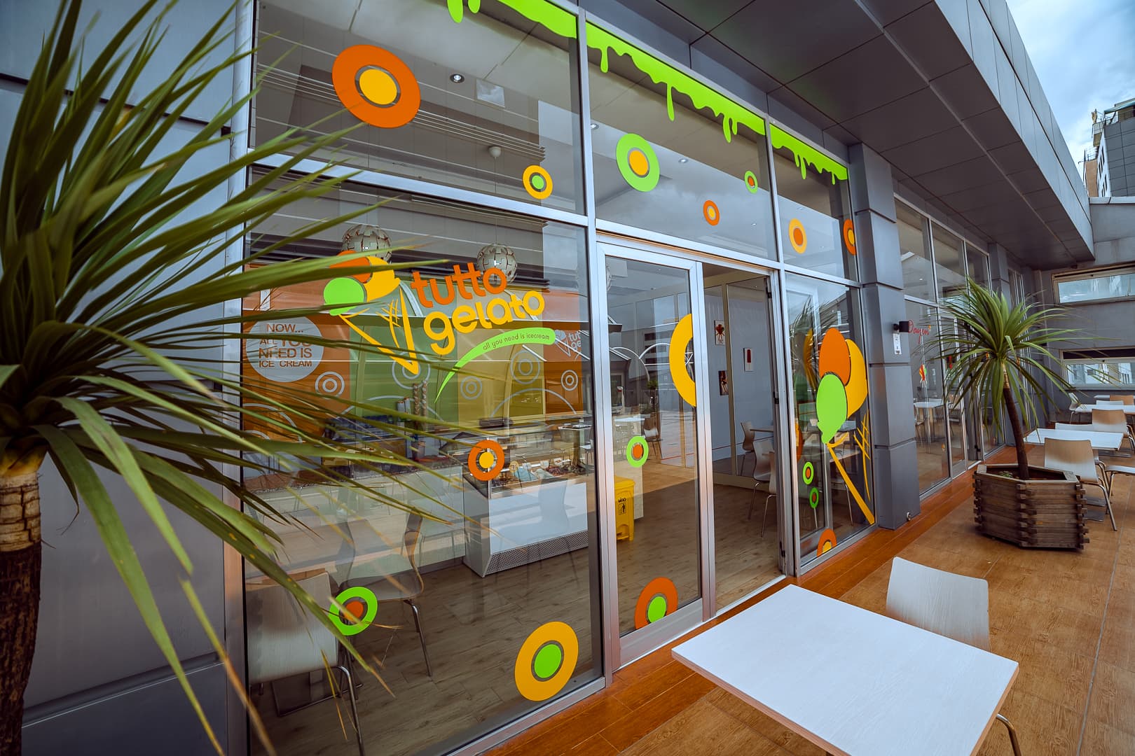 Exterior view of Tutto Gelato storefront with large glass windows and vibrant shop branding